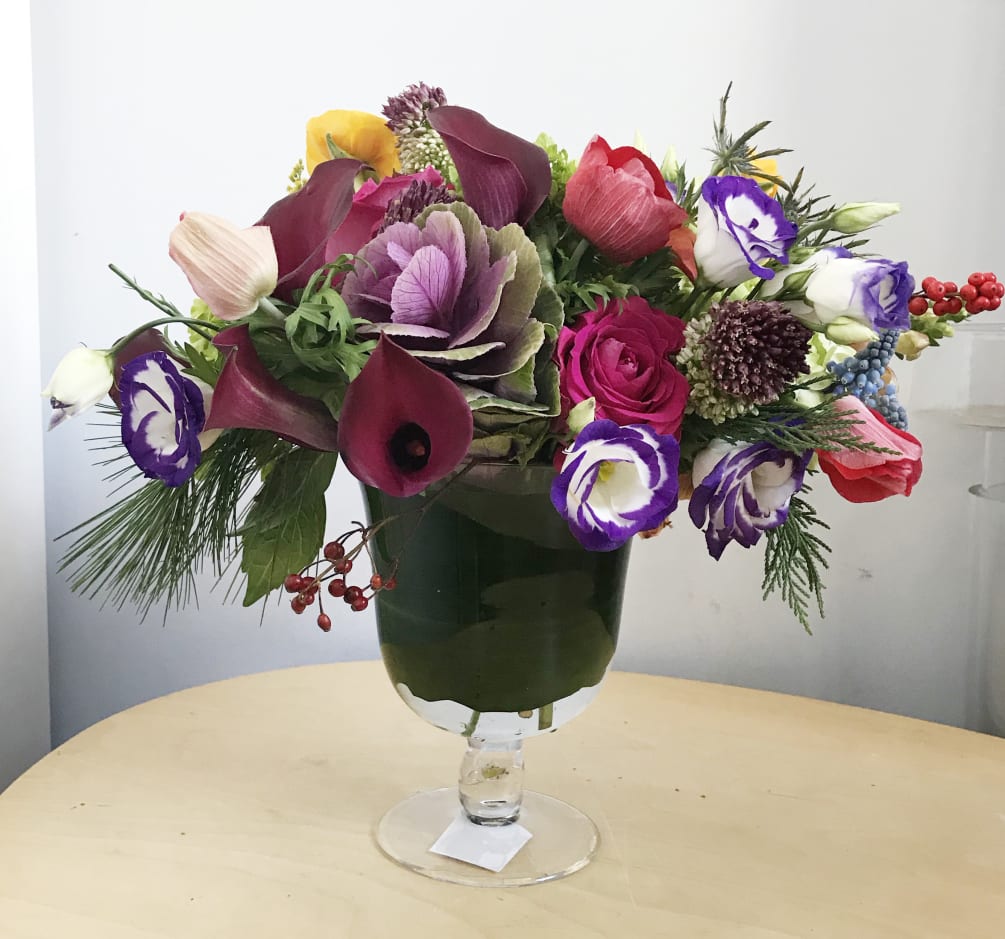 This arrangement are presented in a clear pedestal vase. It&#039;s a very