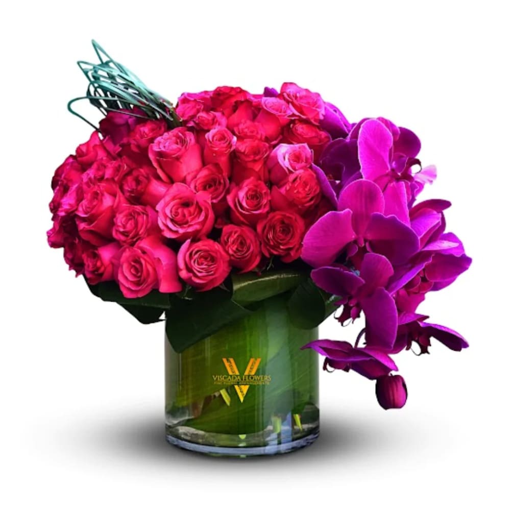 This fiery bouquet features hot pink roses, purple hydrangeas, and greenery, capturing