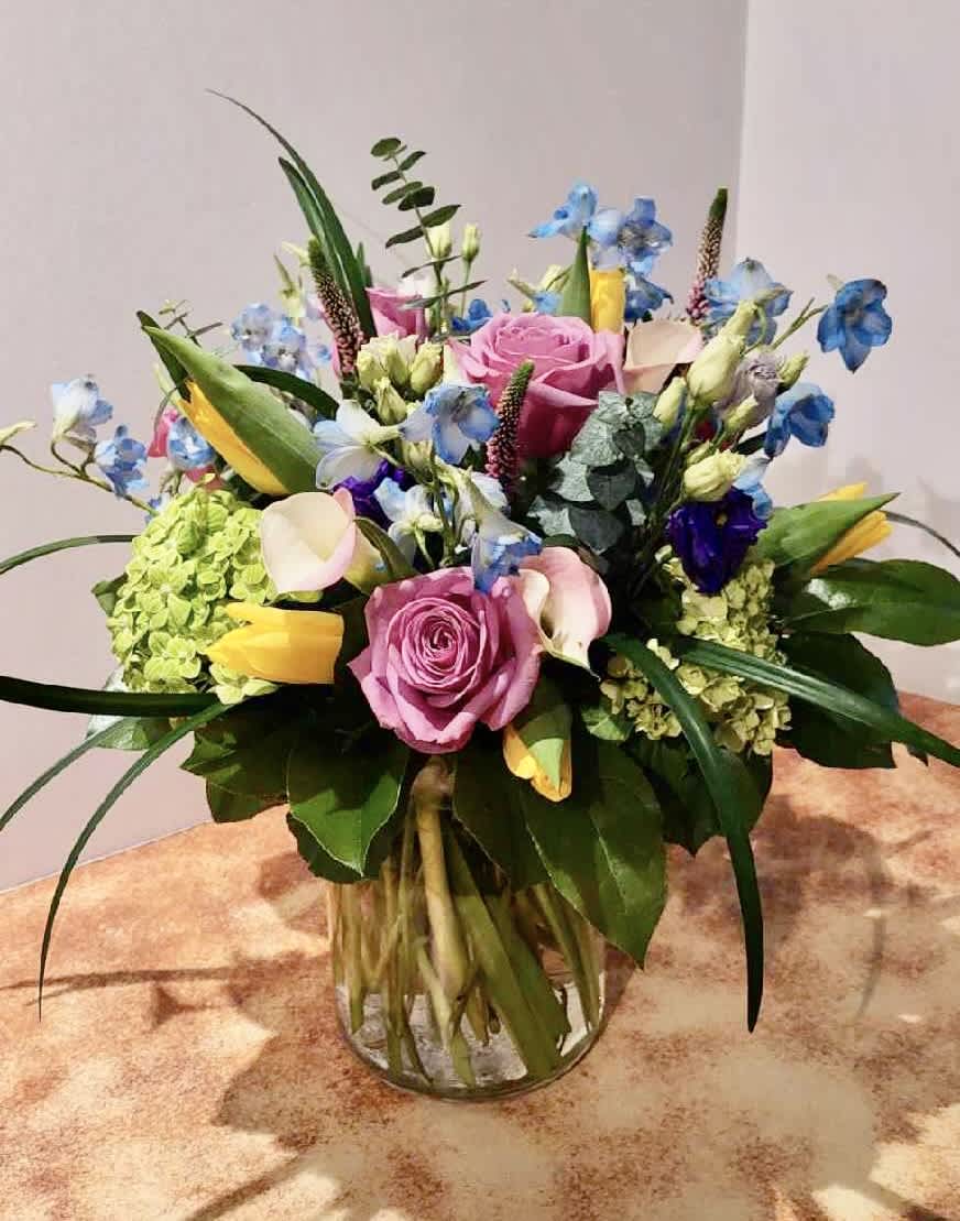 This arrangement is presented in a ginger jar vase. It features blue