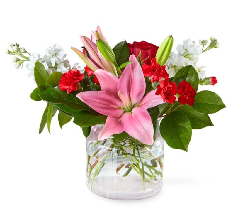 With an abundant blend of colorful blooms in a cinched glass vase