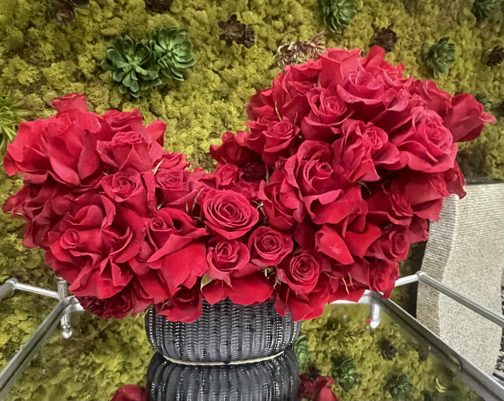 Large red roses in an asymmetrical heart-shaped arrangement.