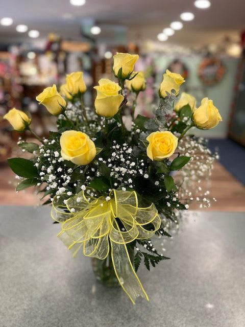 One dozen long stem yellow roses with assorted greens and accent flower