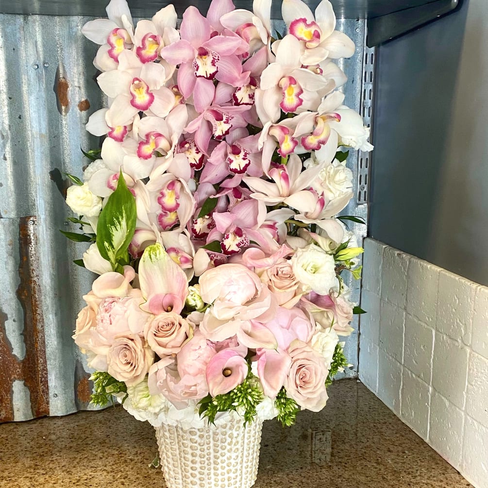 A pastel take on our popular, orchid, hedge style arrangement, this tall