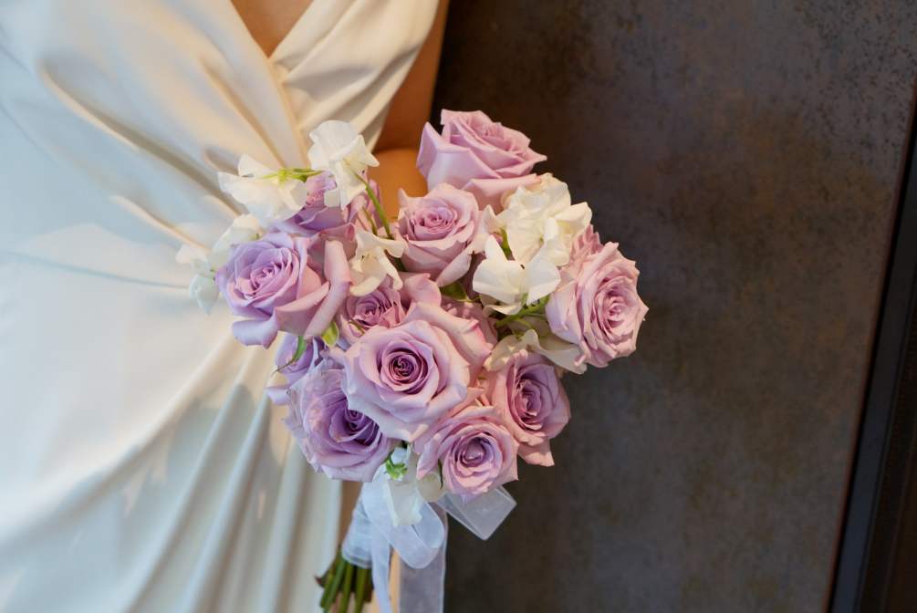Hand tie bridal bouquet with lavender roses and white sweet peas