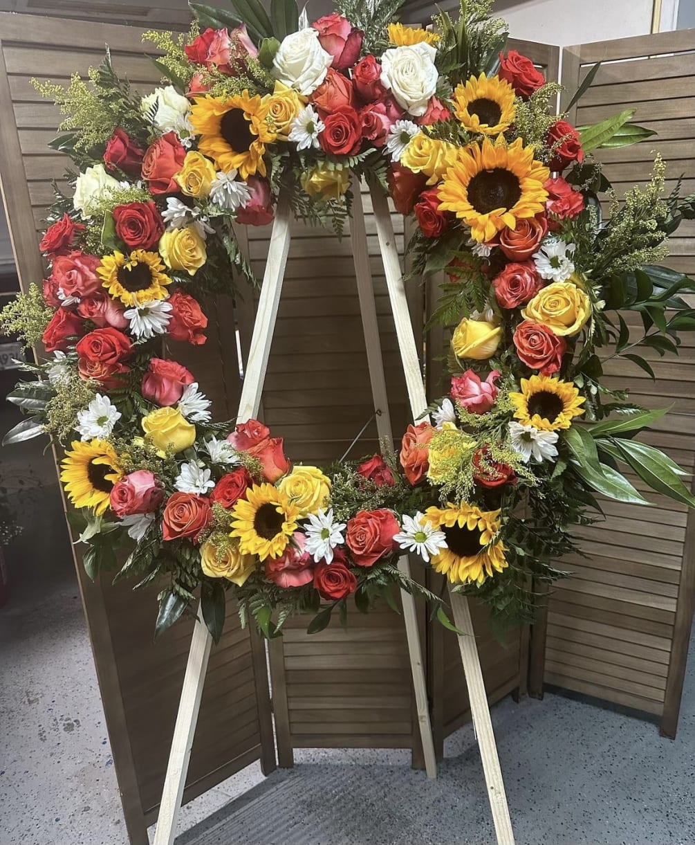 This beautifully designed wreath has a mixture of flowers including sunflowers, daisies