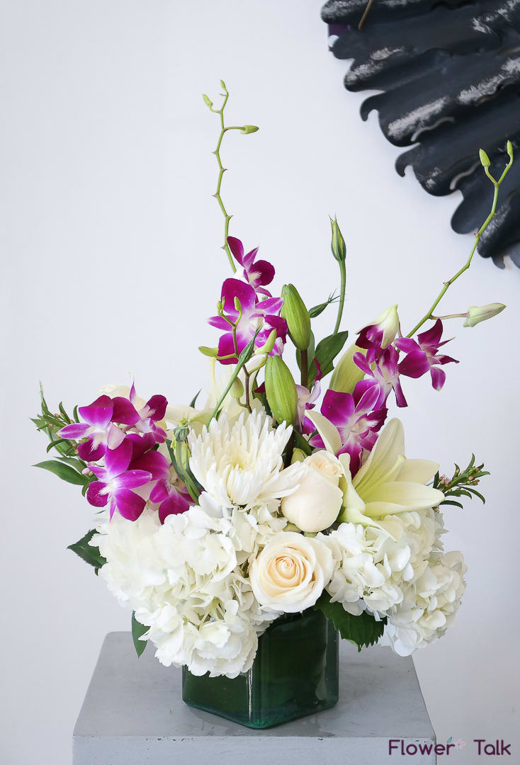 White hydrangeas and mums, purple dendrobium orchids, and white asiatic lilies -
