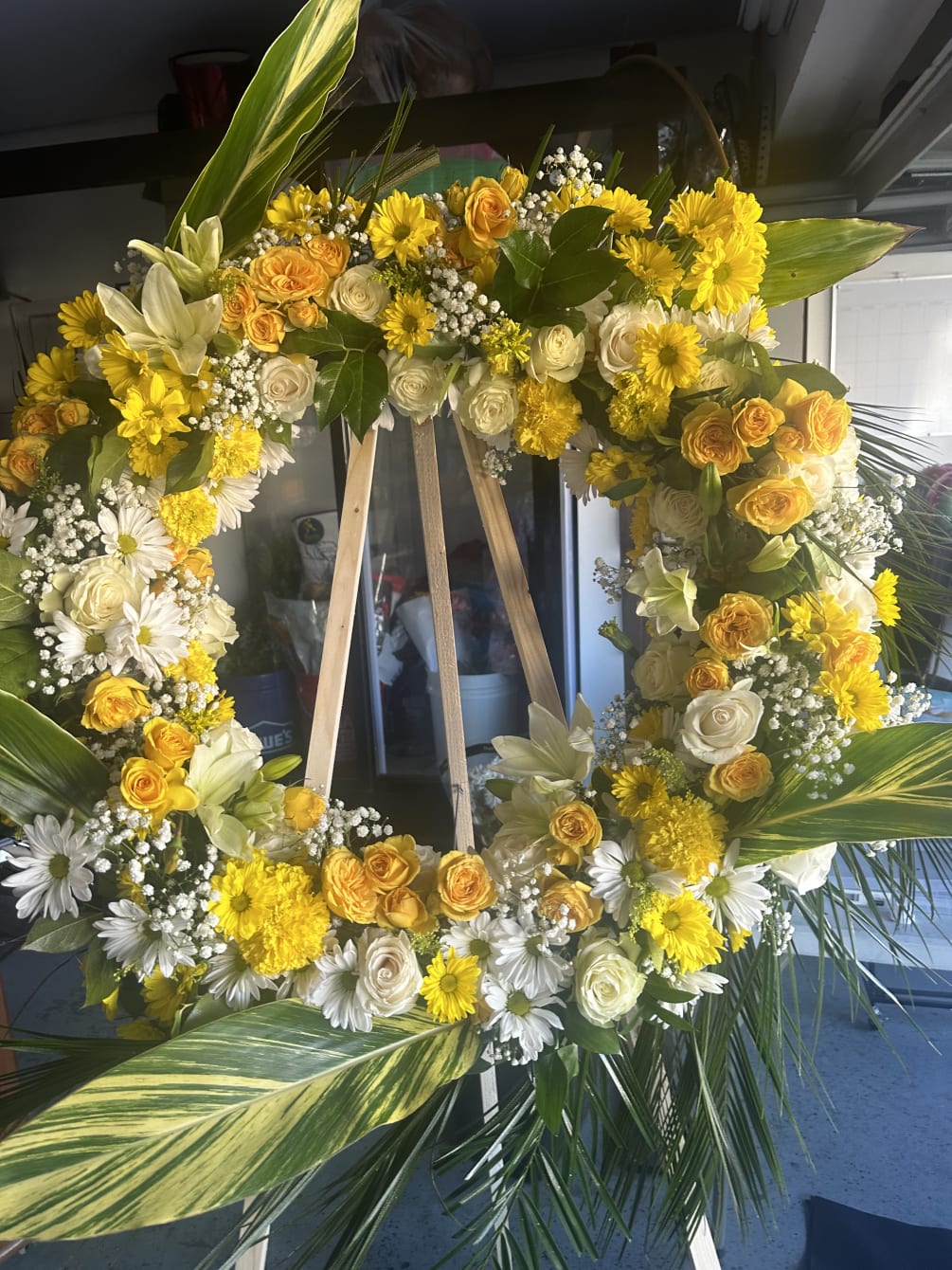 This beautiful wreath is designed with yellow and white roses , yellow