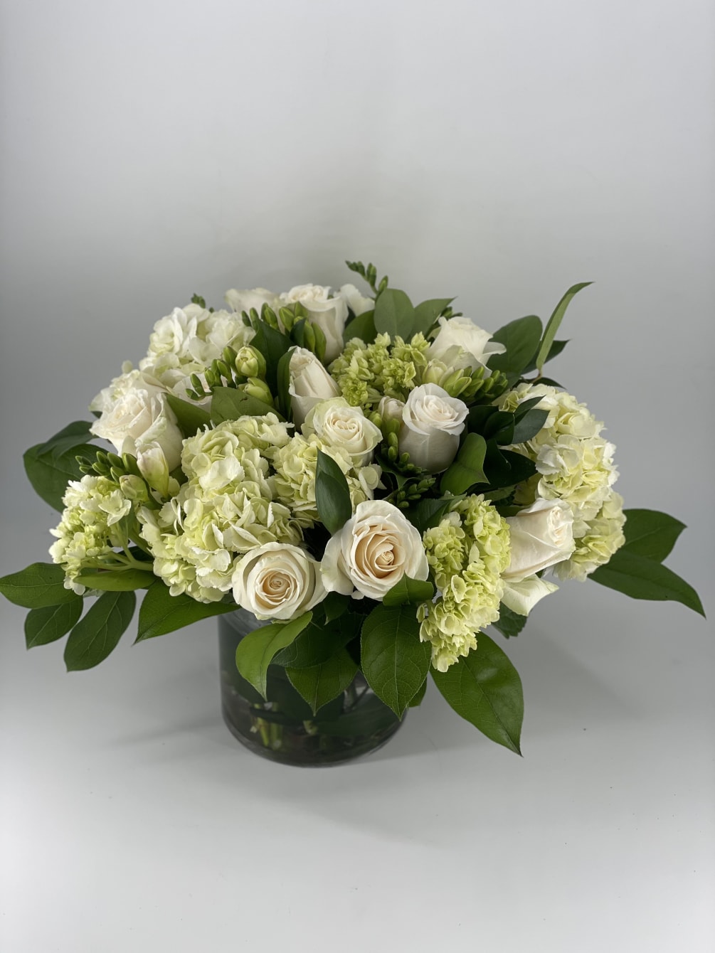 This timeless arrangement is filled with beautiful white blooms such Roses, Hydrangea