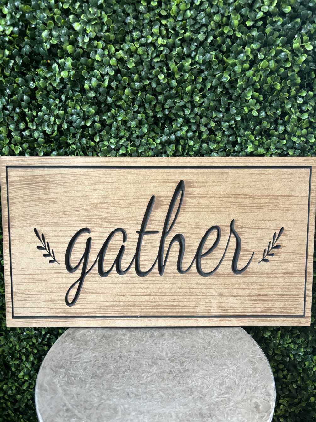 A wooden plaque engraved with &quot;gather.&quot; 