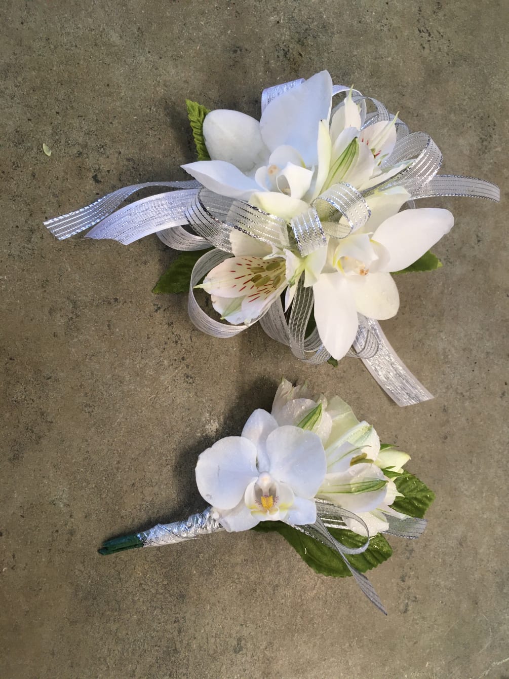 This beautiful white orchid corsage and boutonniere set can be customized for