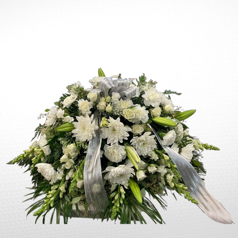 An all white casket piece consisting of disbuds, roses, lilies, and a