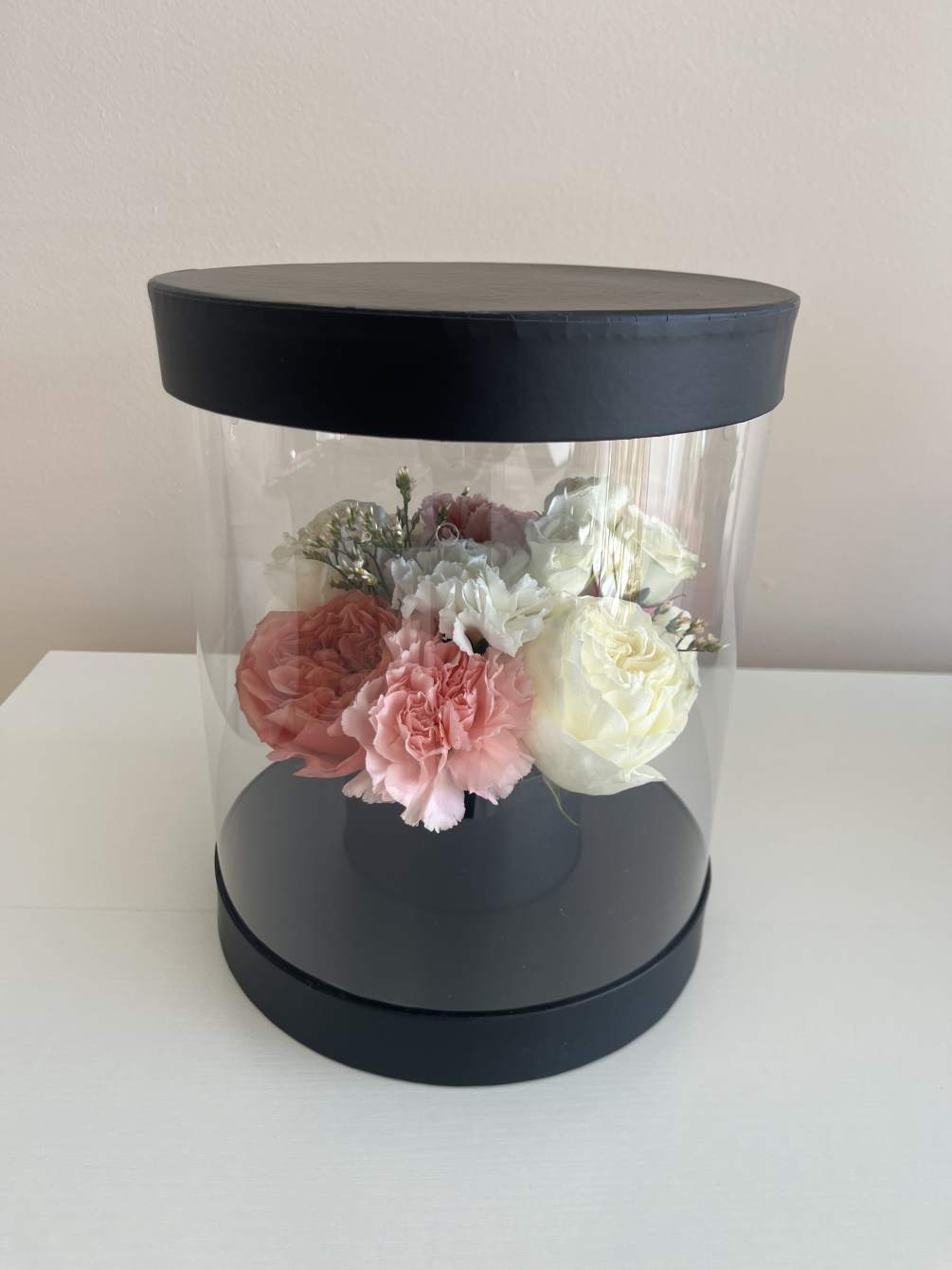 Clear round box, center mixed flowers 

**Please note picture is example of