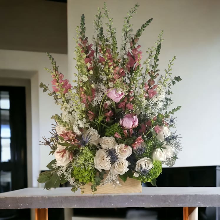 Soft and lovely is this tribute arrangement of the pretties seasonal flowers.