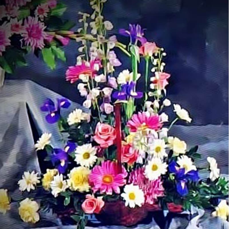 This striking arrangement is a combination of iris, daisies, and carnations to