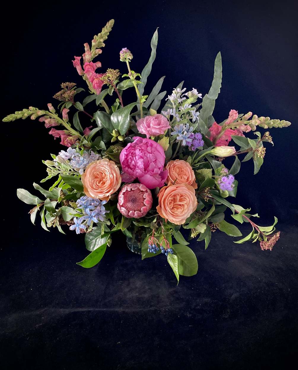 Protea, stunning peony-like Garden Roses, and locally grown unique floral accents create