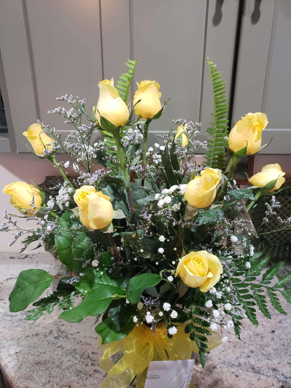 One Dozen yellow or cream Rose&#039;s arranged in a variety of glass