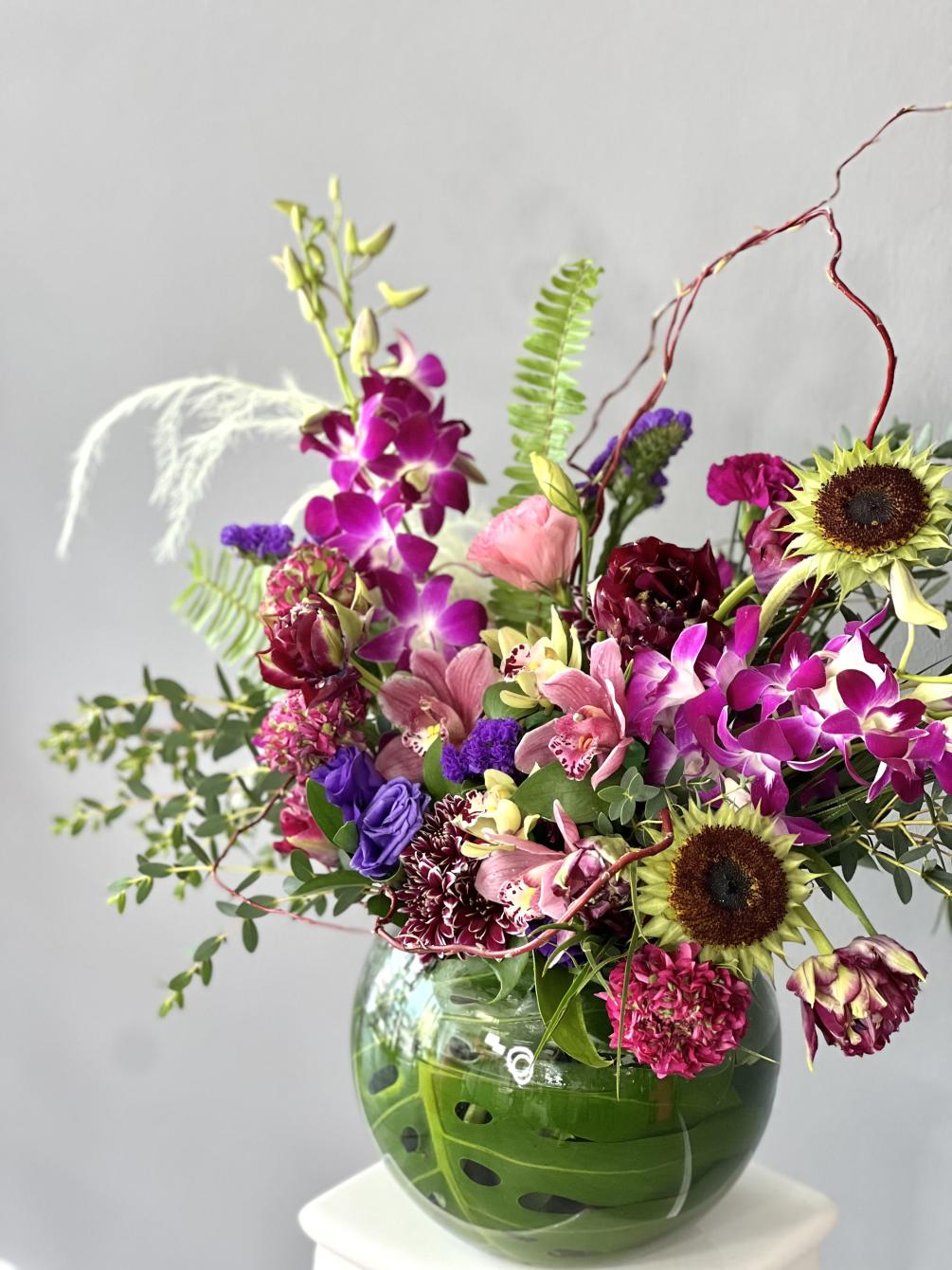 Mix of fresh flowers in green and purple tones arranged in a