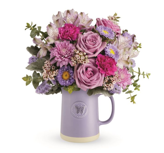 Sweetest Flutter is a pretty purple bouquet designed in a ceramic pitcher.