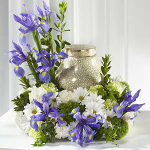 This handcrafted tabletop arrangement of white carnations, white daisies, and blue iris