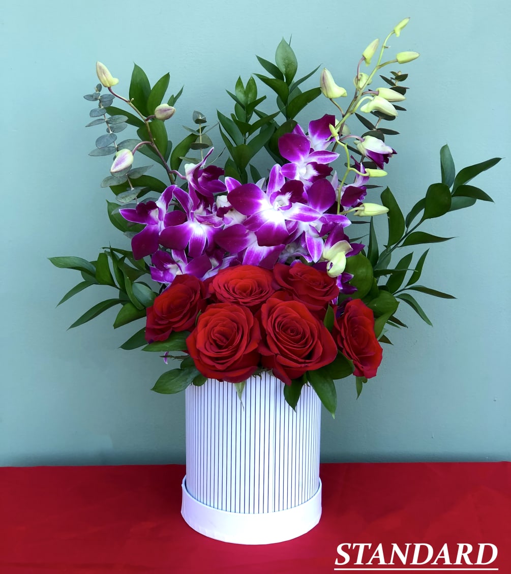 This charming arrangement combines the classic beauty of red roses with the