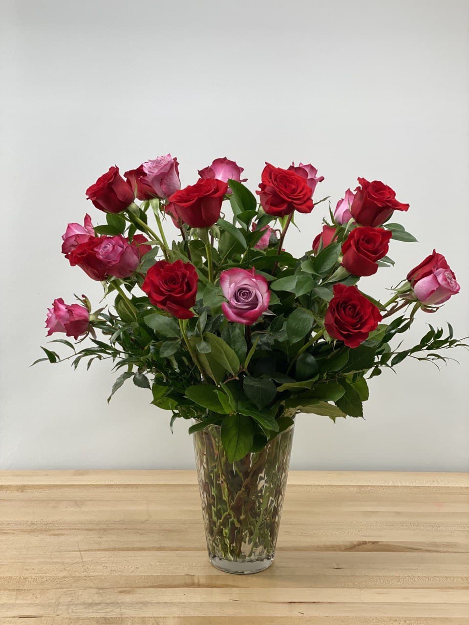 2 dozen long stem red and purple roses in a premium vase.