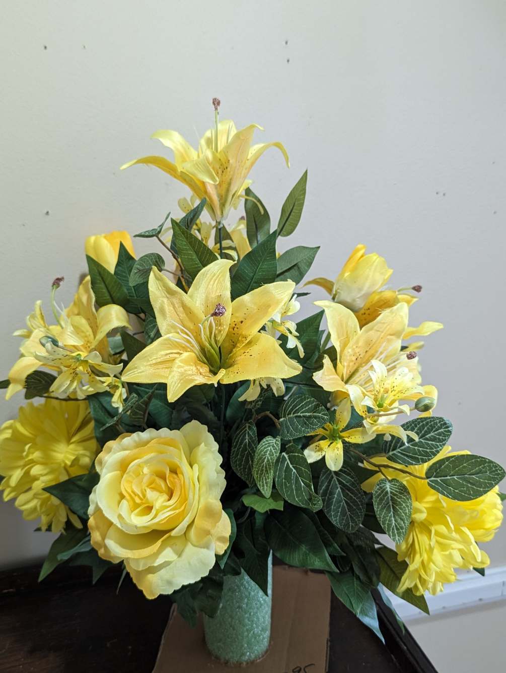 This silk flower arrangement is made of yellow colored flowers complimented by