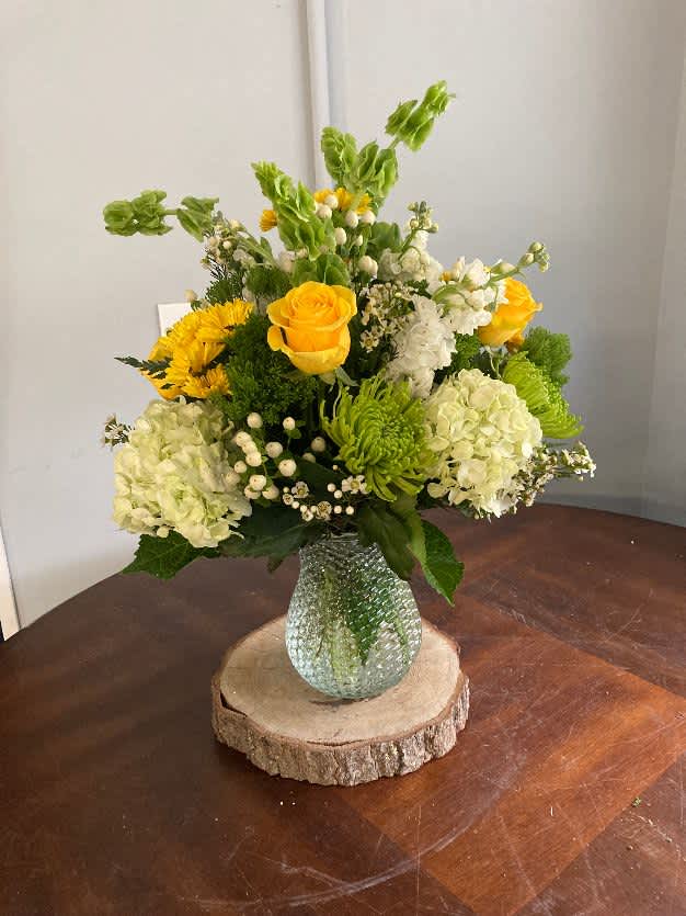 this beautiful assortment of green, white and yellow flowers in a vase.
Hydrangeas