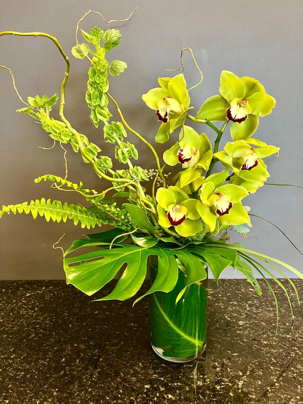 One big, beautiful cymbidium orchid stem accened with tropical greenery, Bells of