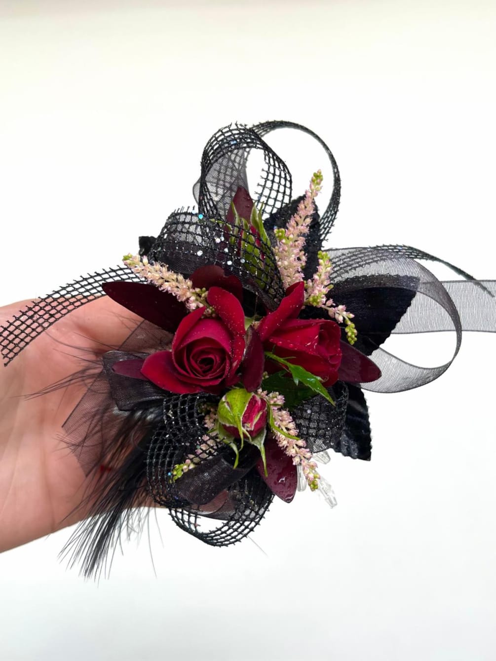 Our premium red and black wrist corsage used dark spray roses and