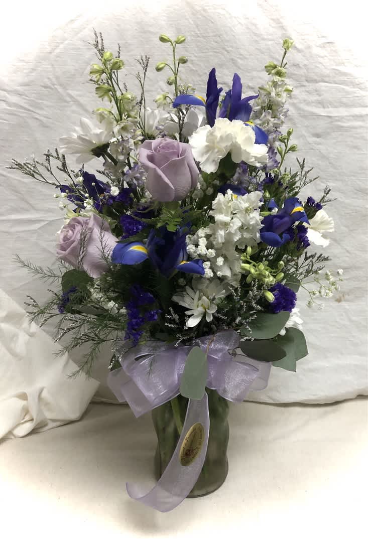 Mixed vase of lavanders and blues, Iris, roses, larkspur and other flowers.
