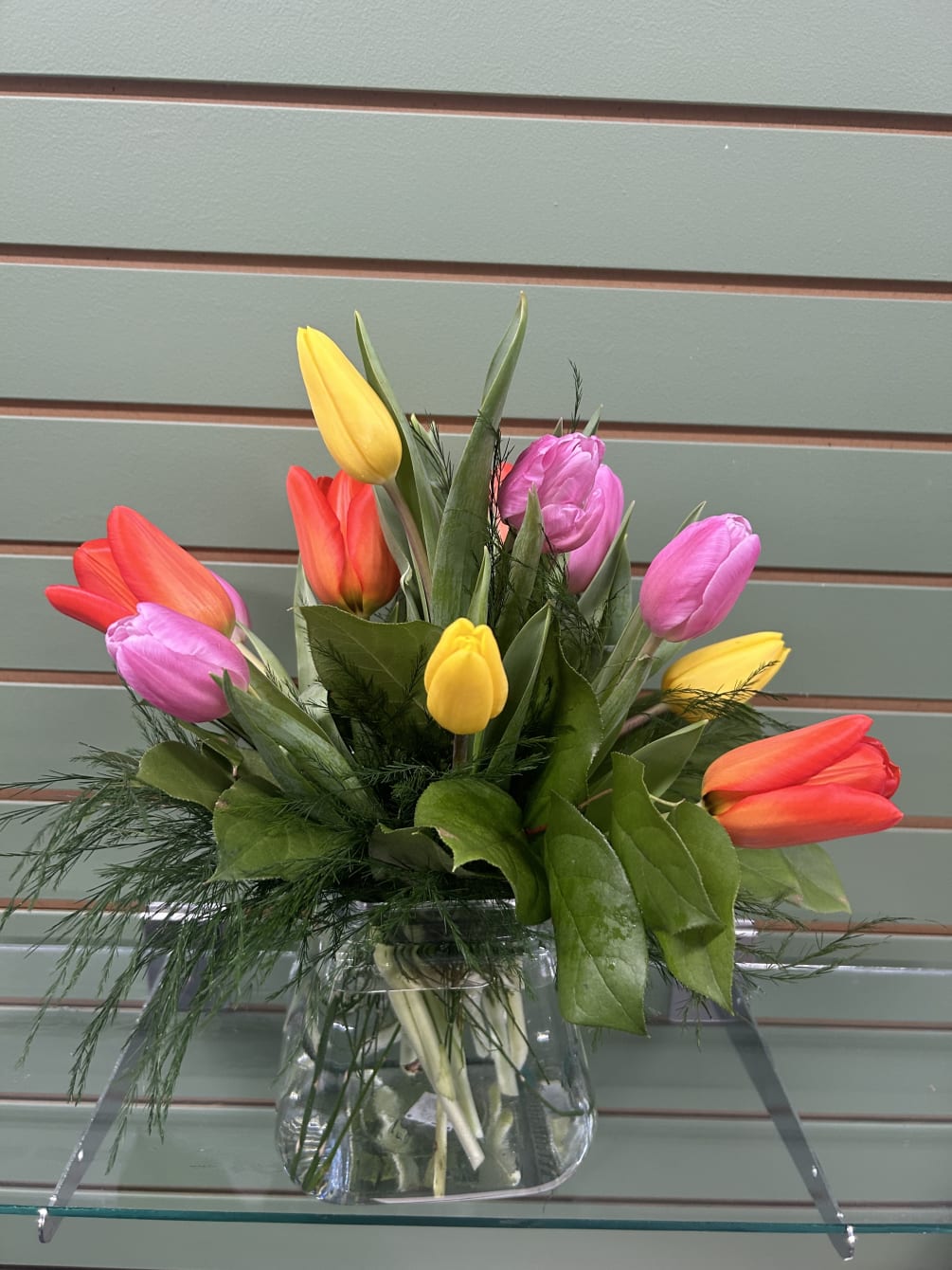 Enjoy 12 brightly colored tulips nestled in soft &amp; simple greenery in