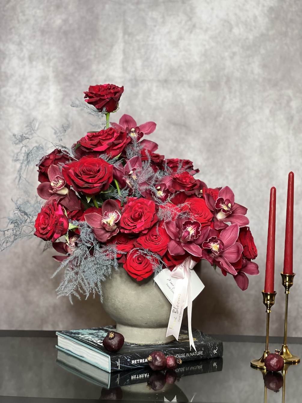 The unique design of mixed red roses and burgundy cymbidium orchids in