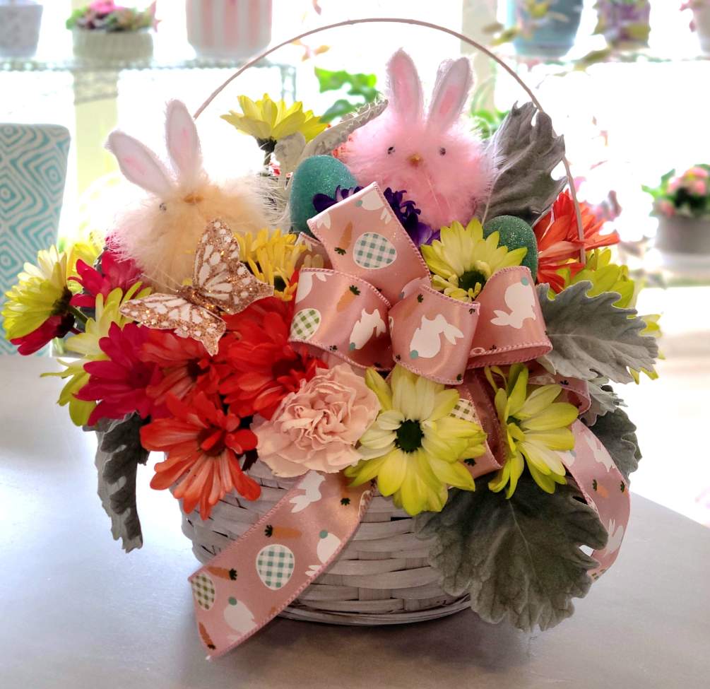 A whimsical spring bouquet featuring multicolored daisies and Easter memorabilia, in a