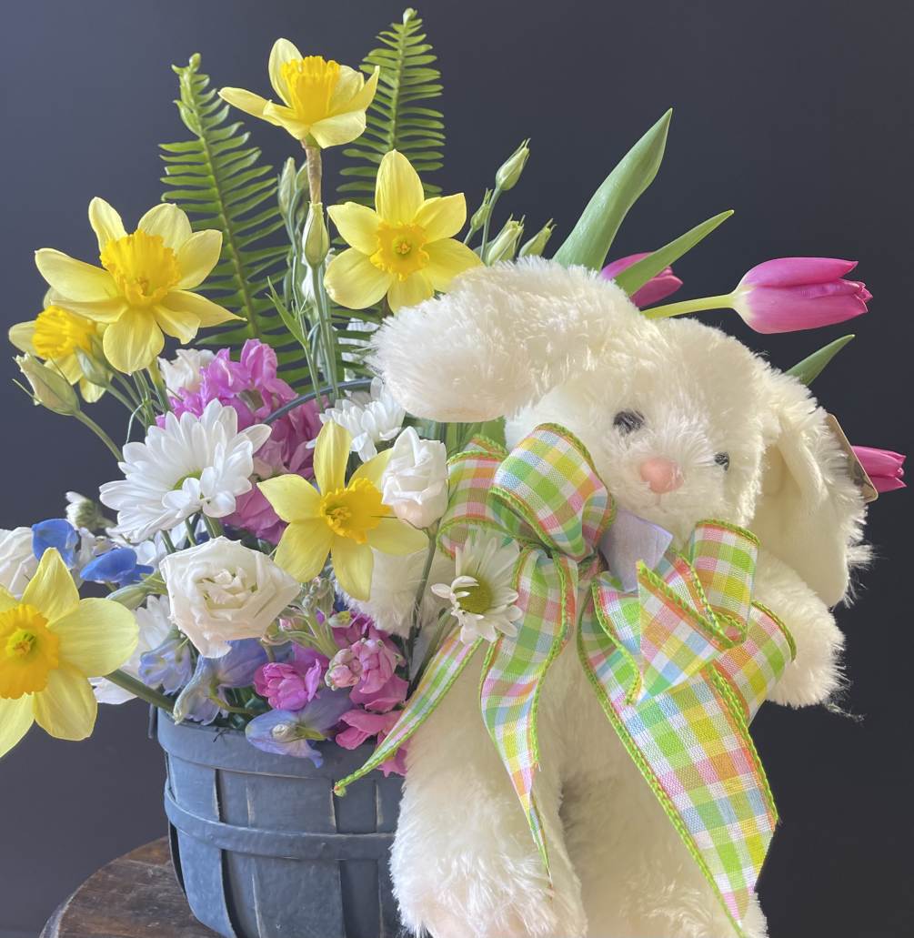 This is a bountiful spring floral basket accompanied by a white rabbit!