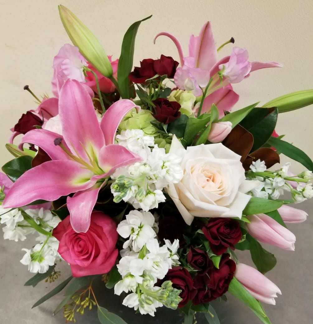 Pink Oriental lilies take center stage against an assortment of red spray