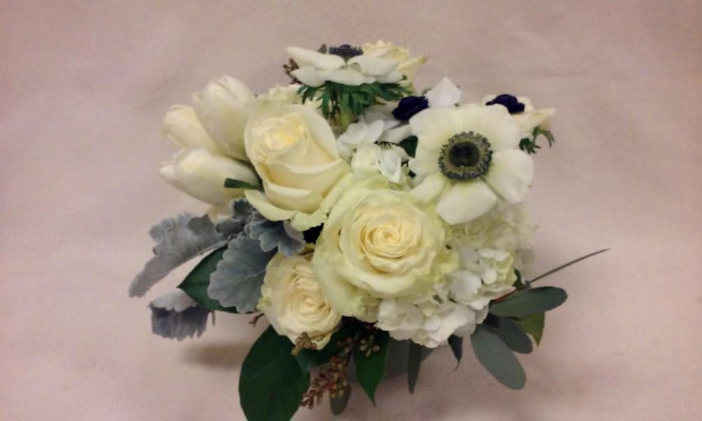 Assorted seasonal white flowers, and hydrangea are arranged en masse. Silvery dusty