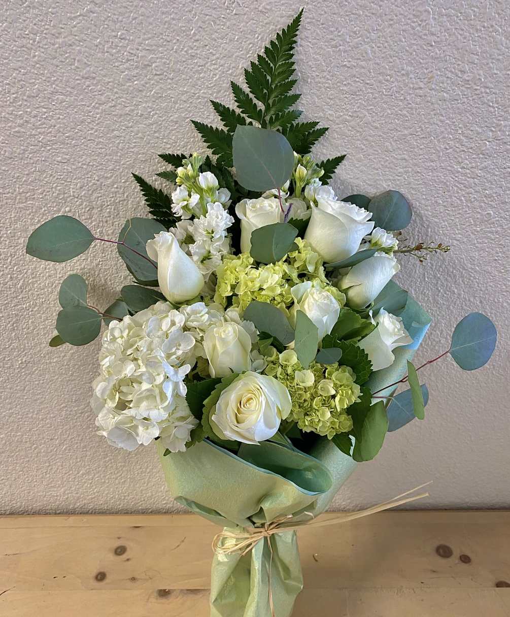 White roses, green hydrangeas, white hydrangeas, white snapdragons, silver dollar, fern, wrapped