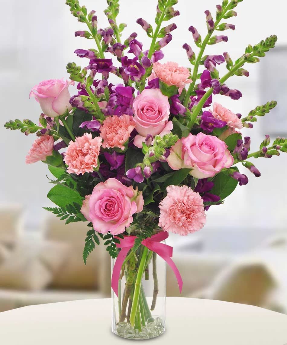 Arrangement has Pink carnation, purple snapdragon, and light pink roses. Beautiful to