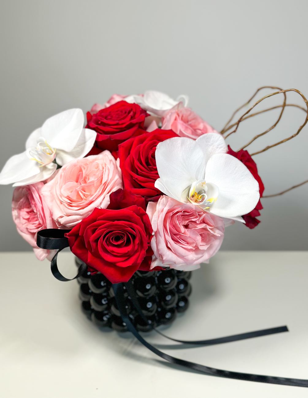 The combination of Pink Garden Rose, Red Rose and White Phalaenopsis Orchid