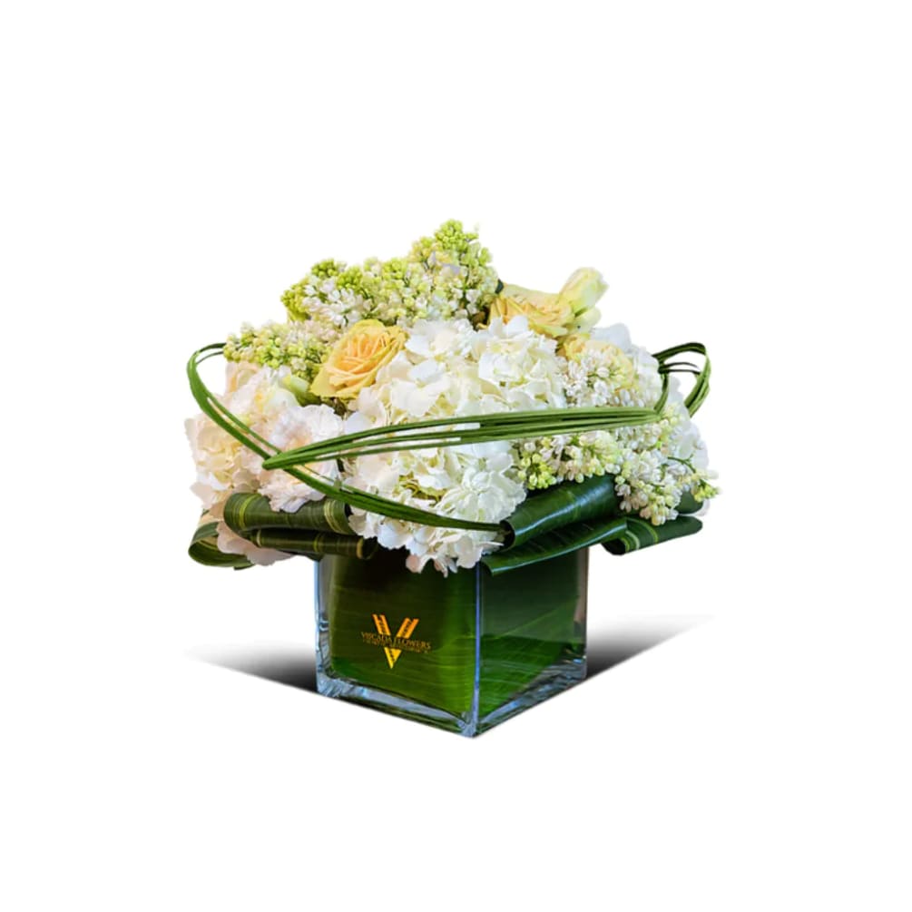 This delightful bouquet showcases white roses, hydrangeas, and greens, combining elegance and