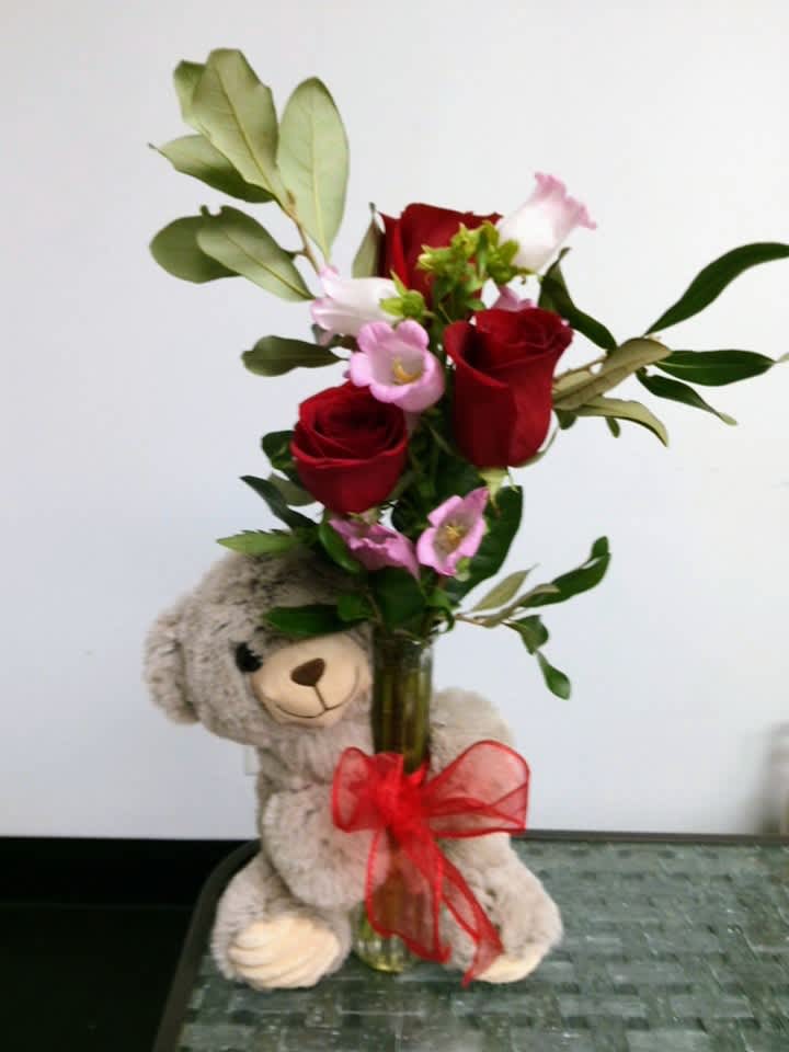Fresh roses in a bud vase held by this cute teddy. About