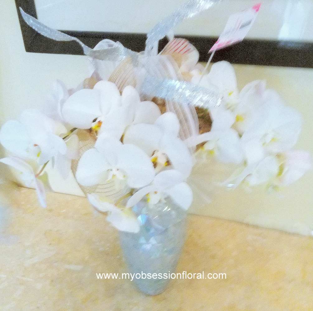 Fresh floral arrangement of orchids in beautiful mosaic vase. Great for any