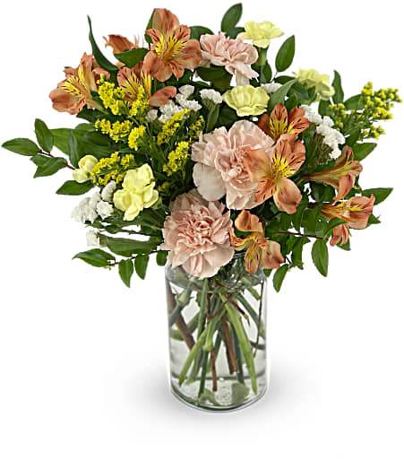 A beautiful bouquet including carnations, alstroemeria and aster in a clear vase.