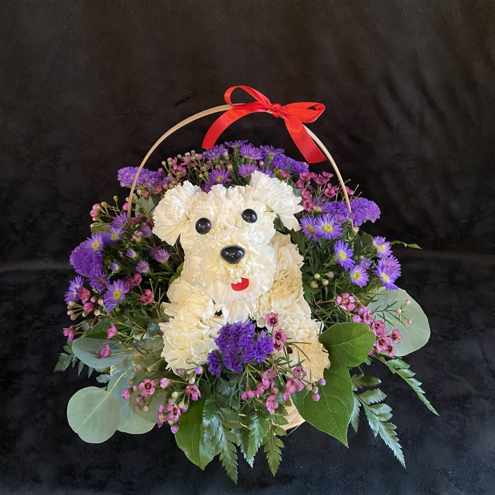 Floral puppy surrounded by blooms in a basket.
