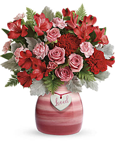 This bouquet features pink spray roses, red alstroemeria, red carnations, pink miniature