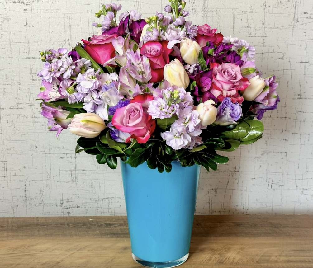 Our signature Tiffany Vase with tulips and purple roses. This one has