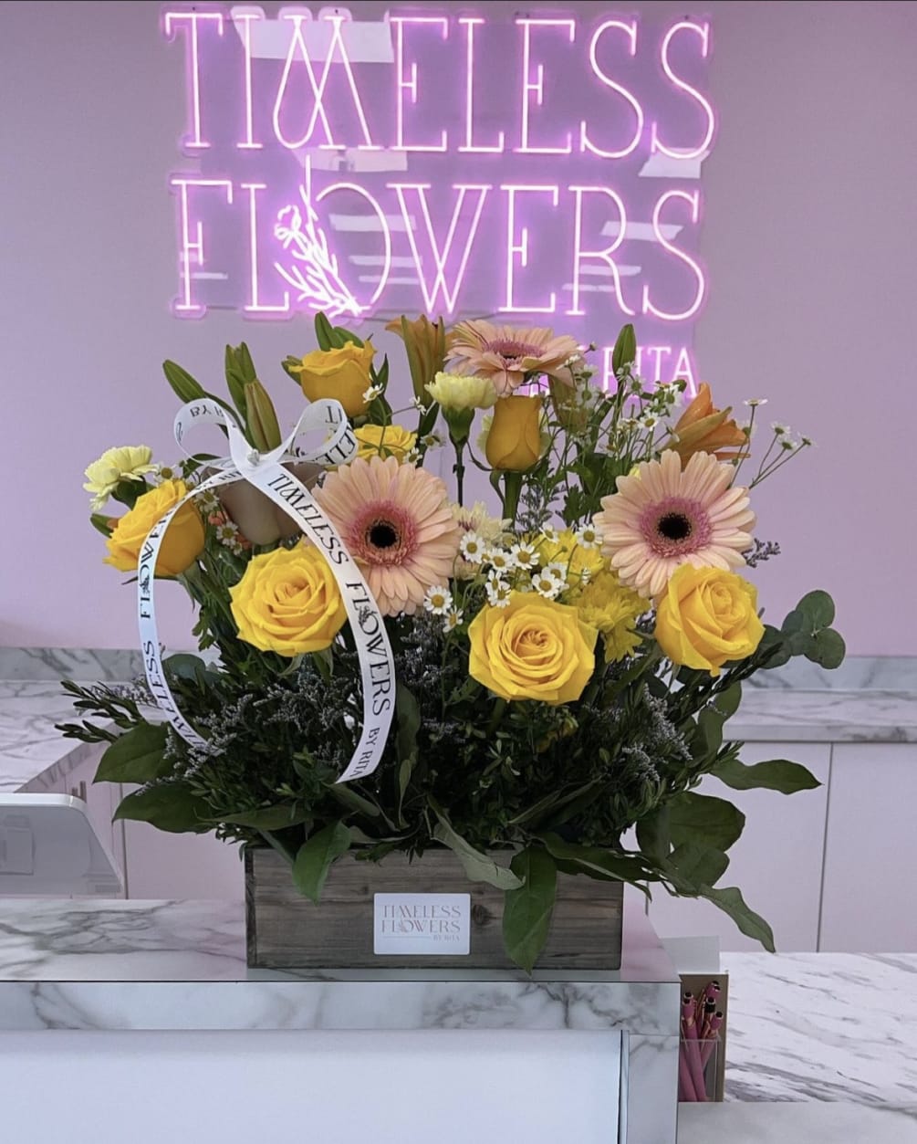 A unique array of pink and yellow florals with lush greenery and
