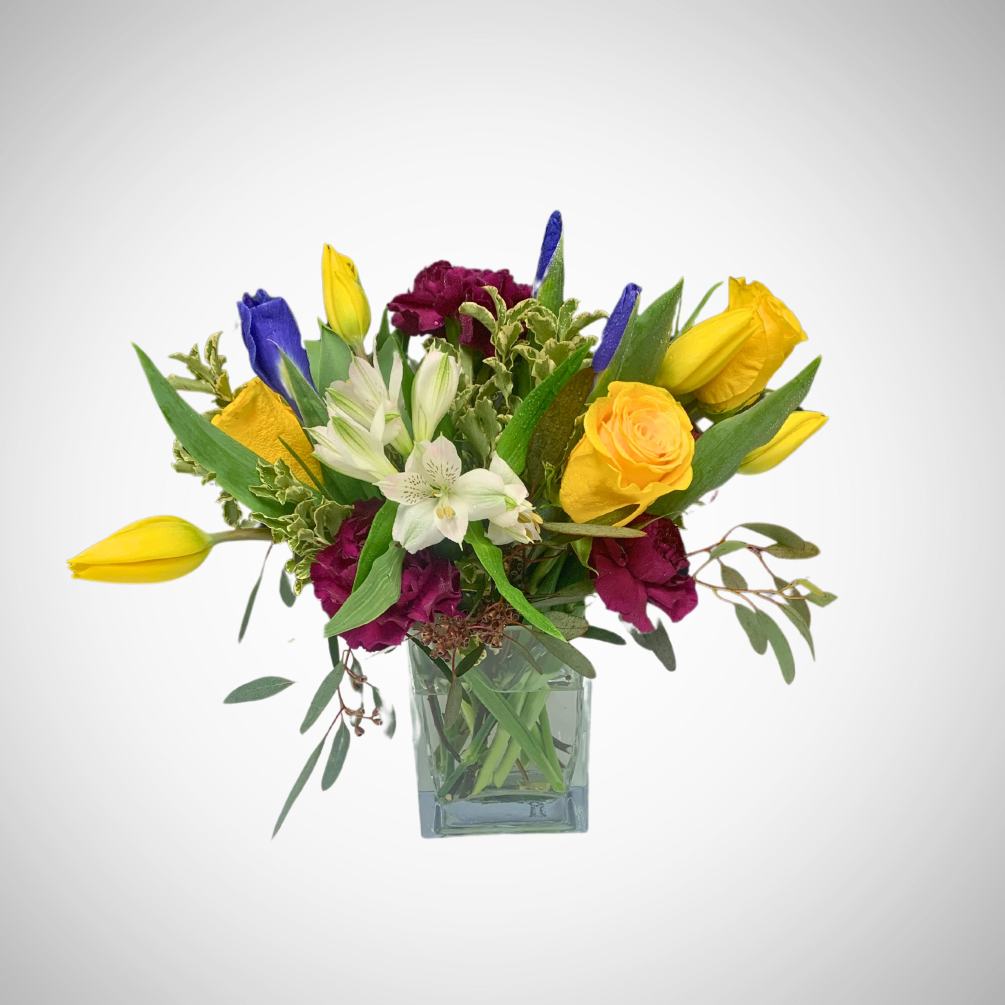 A sophisticated and vibrant bouquet of spring blooms. Fresh yellows, garnet, purple