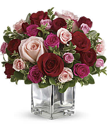 Assortment of pinks and red roses in a clear vase