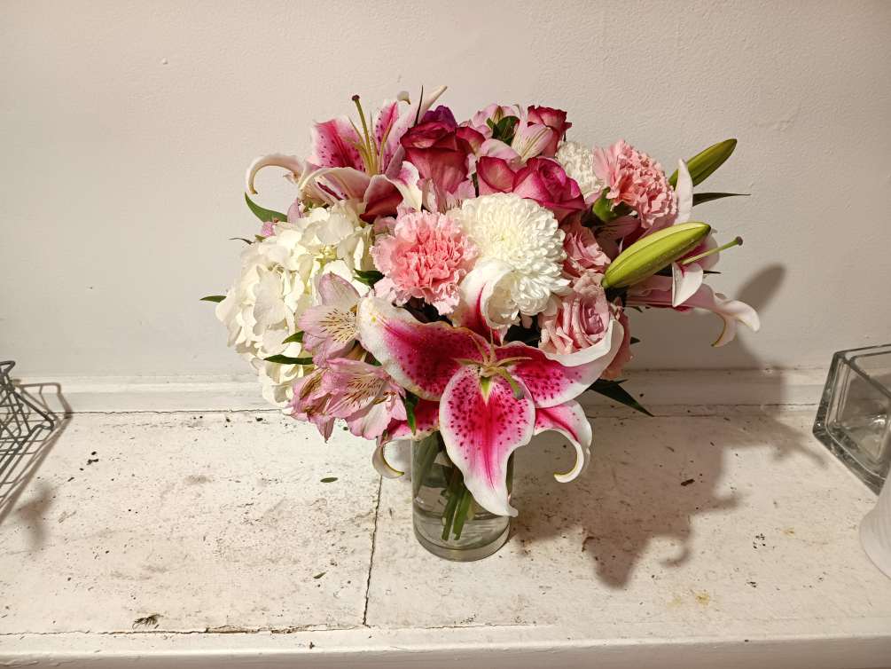 Beautiful stargazer lily, pink roses and carnations in a vase